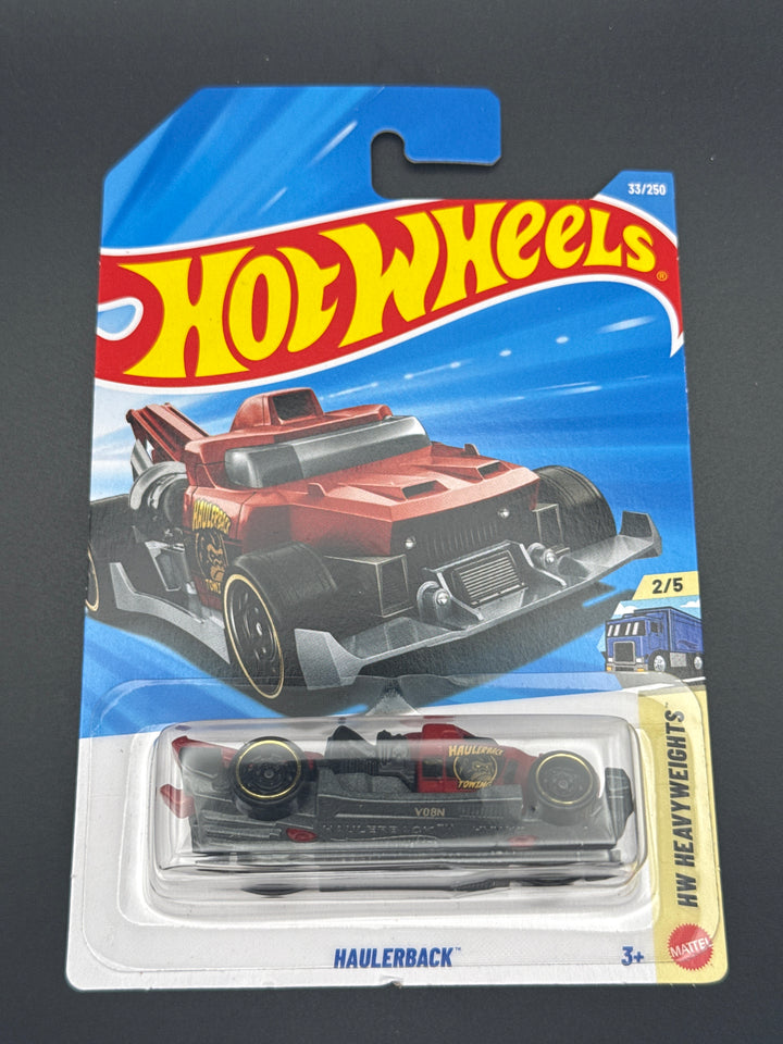 Hot Wheels Haulerback in black and red on its mainline blister card, HW Heavyweights series